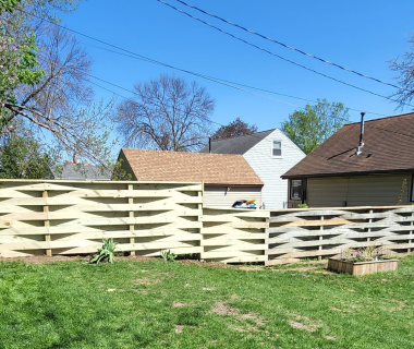 Backyard with new tan privacy fence and neighboring houses visible