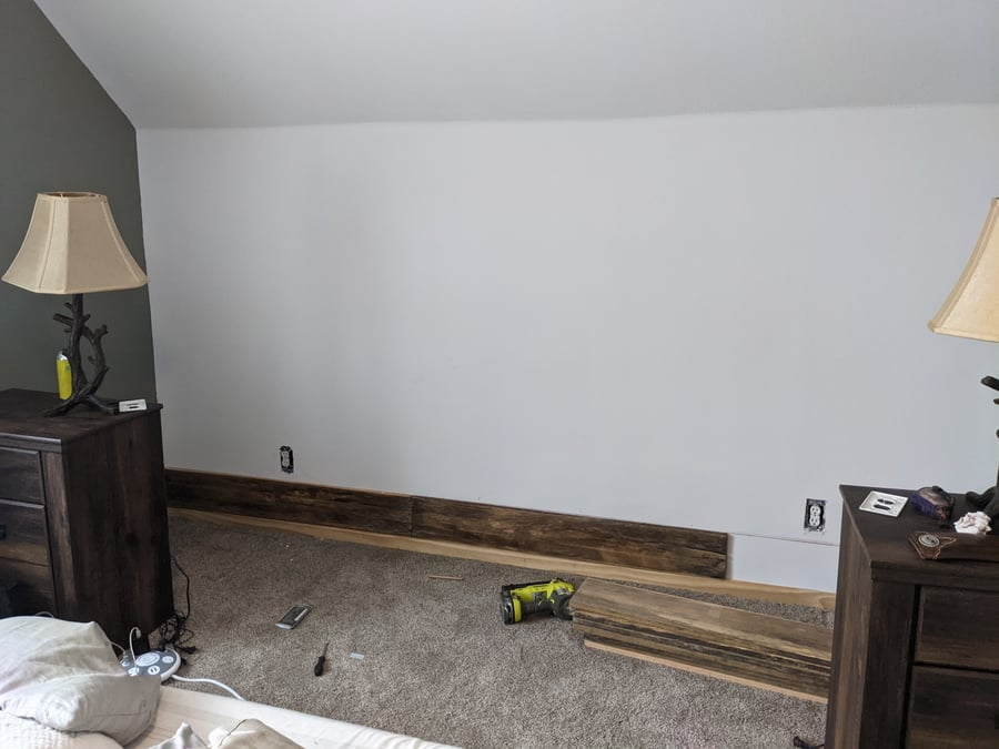 Unfinished room with baseboards removed and tools on carpet