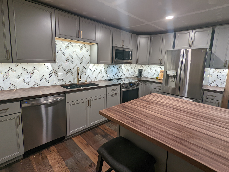 Modern gray kitchen with white tile backsplash and wooden island
